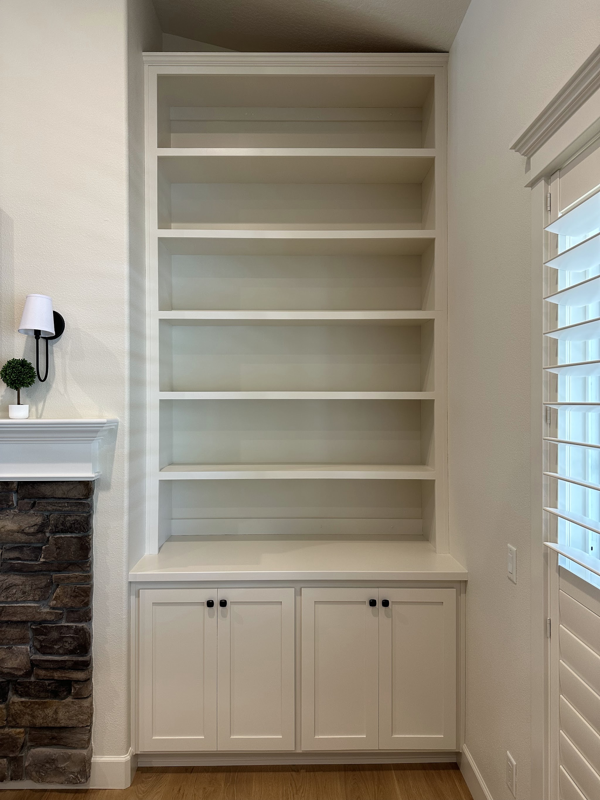 Built-in bookshelves beside a stone fireplace